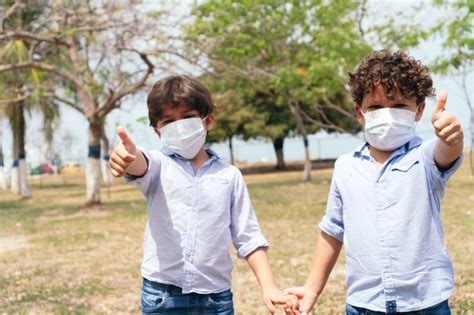 Dos niños con máscaras protectoras en el parque Foto Premium