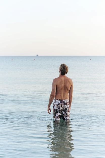 Premium Photo Shirtless Man Swimming In Sea Against Sky