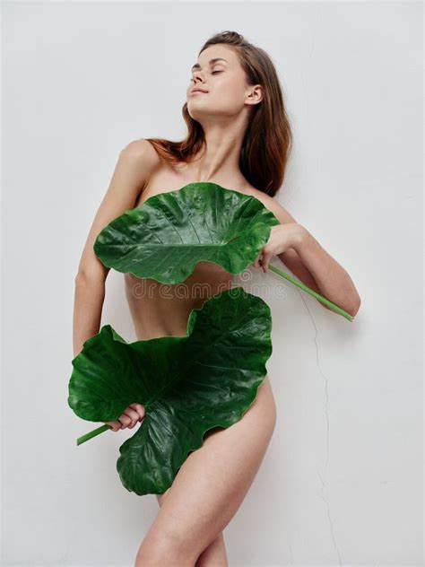 Woman With Green Leaves Cover Naked Body Parts With Closed Eyes Stock
