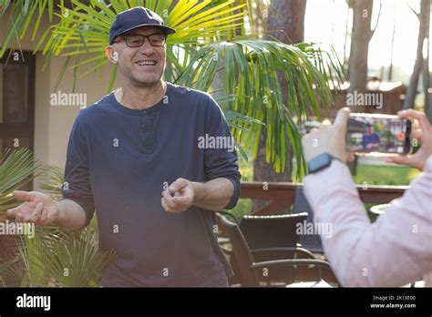 Mature Joyful Man In Cap And Glasses Teaching Gesturing On Recording