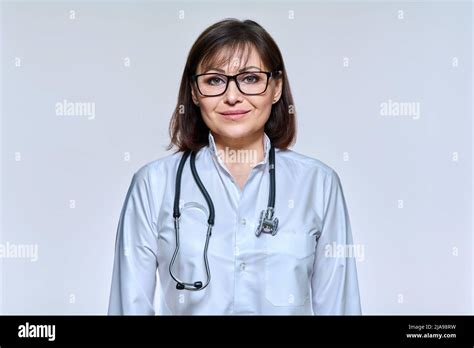 Portrait Of Mature Woman Doctor With Stethoscope On Light Studio