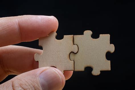 Premium Photo Cropped Hand Of Person Holding Jigsaw Pieces Against