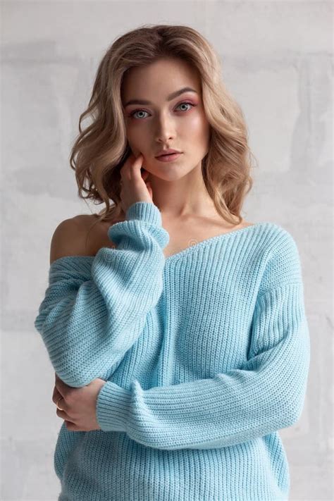 Blonde Girl In A Blue Knitted Sweater On A White Wall Background Stock Photo Image Of Healthy