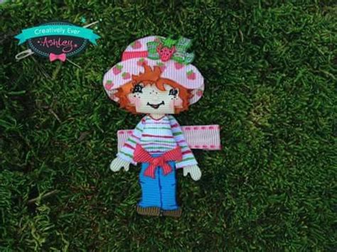 A Stuffed Doll Is Laying On The Ground Next To Some Green Grass And A Sign