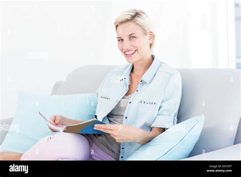 Pretty Blonde Woman Reading A Magazine On The Couch Stock Photo Alamy
