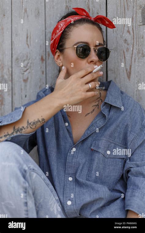 Beautiful Young Stylish Woman With Sunglasses And A Red Bandanna In A Denim Shirt And Vintage