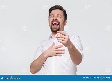 Mature Caucasian Man With A Beard Laughs Holding His Stomach And