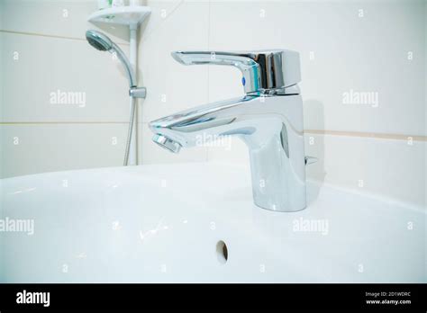 Chromed Metal Faucet For Hot And Cold Water In A Modern Bathroom Stock Photo Alamy