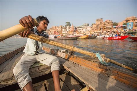 Boatmen On A Boat Glides Through Water On Ganges River Along Shore Of