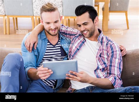 Gay Couple Relaxing On The Couch Using Tablet Stock Photo Alamy