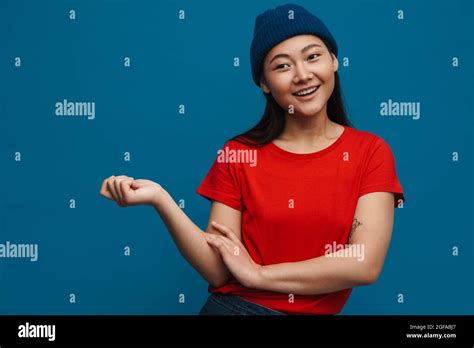 Happy Young Asian Woman In Casual Clothes Standing Over Blue Wall