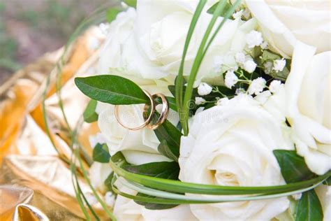 Mazzo Delle Rose Bianche Con Il Primo Piano Delle Fedi Nuziali Dorate