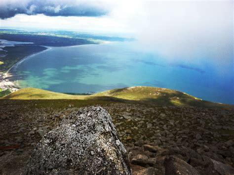 a view from the top of a mountain looking down at water and land