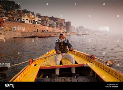 India Uttar Pradesh Varanasi Man Rowing Boat Taking Tourists On Dawn