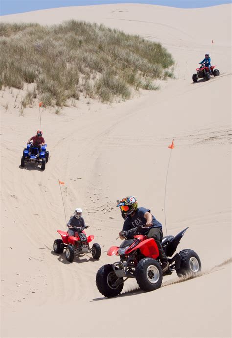 Quads Racing Down a Dune - Torex ATV Rentals