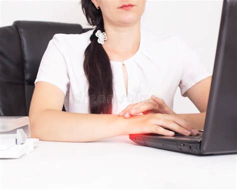 The Girl In The Office While Working At The Laptop Holds The Wrist