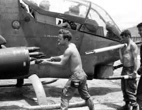 Some Men Are Standing Next To An Old Plane And One Is Holding Something