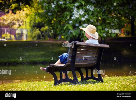 Vieille Dame Assise Sur Un Banc En Bois Banque De Photographies Et D