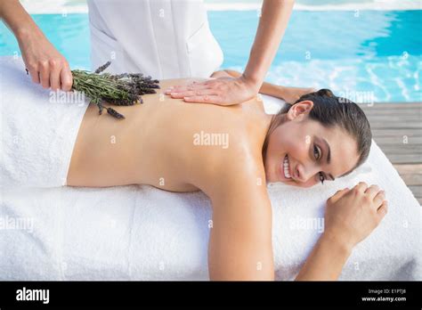 Smiling Brunette Getting An Aromatherapy Treatment Poolside Stock Photo
