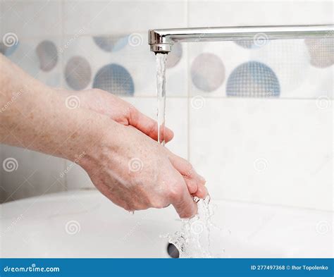 Washing Hands With Liquid Soap In A Bottle Under The Faucet In The