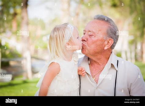 Loving Grandfather And Granddaughter Kissing Outside At The Park Stock