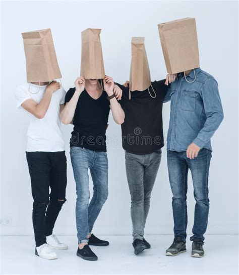 Grupo De Gente Joven Con Las Bolsas De Papel En Sus Cabezas Imagen De