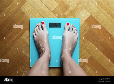 Woman Standing On Weighing Scales Stock Photo Alamy