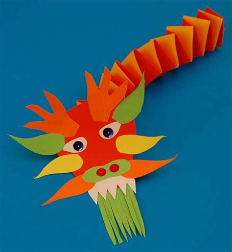 An Orange And Green Dragon Head Made Out Of Paper