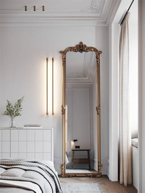 A Large Gold Framed Mirror In A White Bedroom