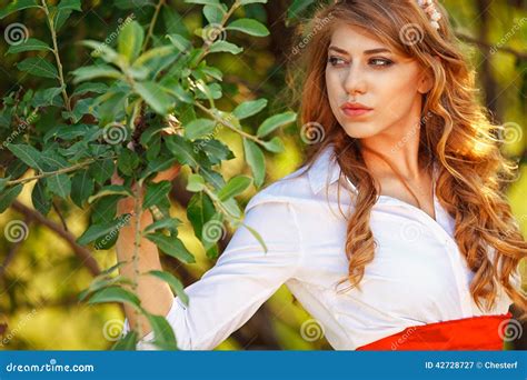 Blonde Gelockte Frau Unter Dem Baum Steht Stockbild Bild von mädchen wald