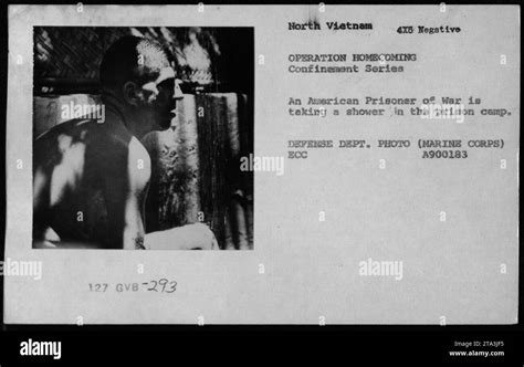 An American Prisoner of War is shown taking a shower in a prison camp ...