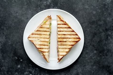 Sándwiches con jamón queso tomate lechuga y pan tostado en un plato