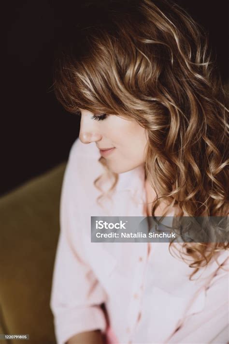 Portrait Of A 36 Years Old Woman With Curly Hair And Brown Slanting