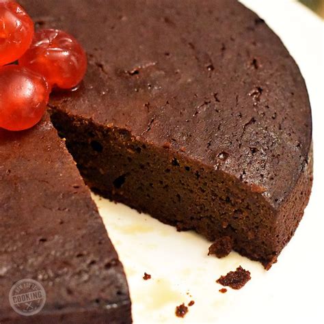 A Chocolate Cake With One Slice Cut Out And Cherries On Top