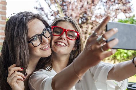 Two Female Young Friends Take A Selfie Hugged Together Stock Photo