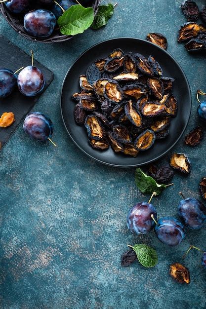 Premium Photo | Dried prune and fresh plums with leaves