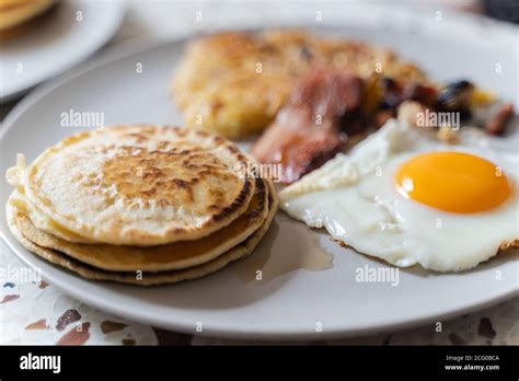 A breakfast with eggs, pancakes, bacon and hash browns Stock Photo - Alamy