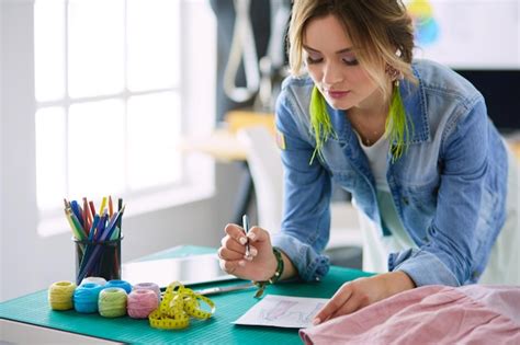 Mujer diseñadora de moda trabajando en sus diseños en el estudio