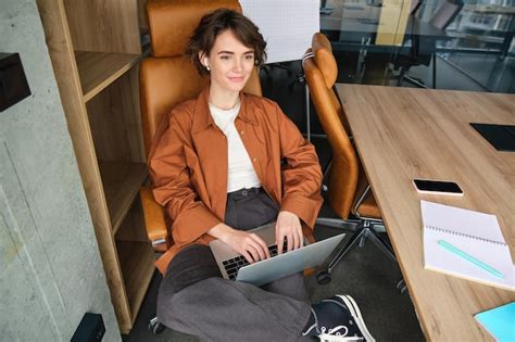 Portrait D Une Jeune Femme Souriante Qui Travaille Au Bureau Et Utilise