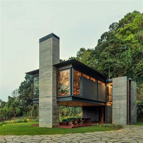 A Modern House In The Middle Of A Lush Green Forest