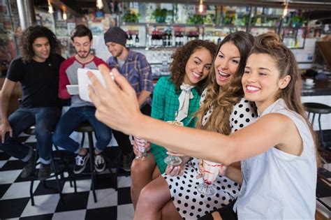 Premium Photo Cheerful Female Friends Taking Selfie In Restaurant