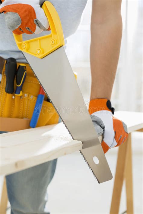 Midsection De La Madera Del Sawing Del Hombre En Nueva Casa Imagen De