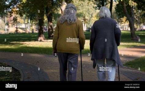 Two Old Ladies Enjoying Walk In Park Nursing Home For Elderly People