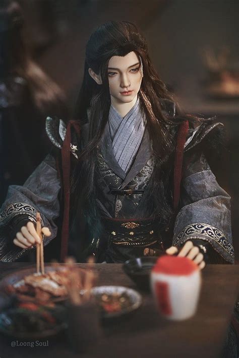 A Doll Is Sitting At A Table With Chopsticks In Her Hand And Looking Down