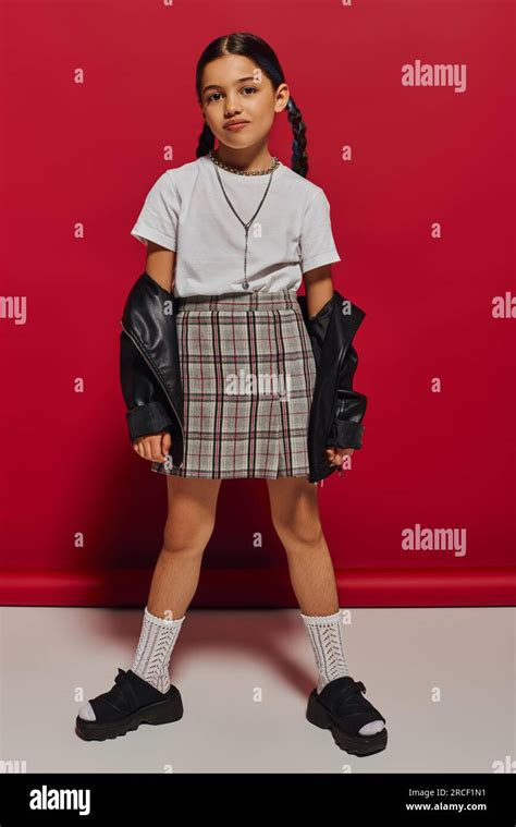 Toute la longueur de la fille preteen brunette tendance avec coiffure posant dans la jupe à