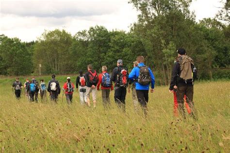 A Group Of People Standing In The Middle Of A Field With Backpacks On