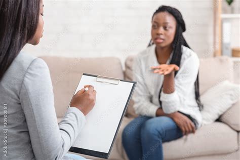 Psychologist Taking Notes During Therapy Session With Her Emotional