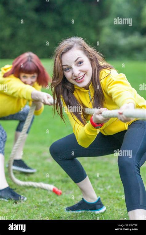 Young Women Playing Tug Of War On Field Stock Photo Alamy