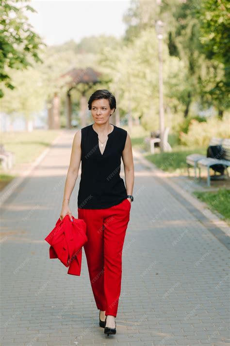 Premium Photo Portrait Of A Girl In A Red Suit Standing In The Alley