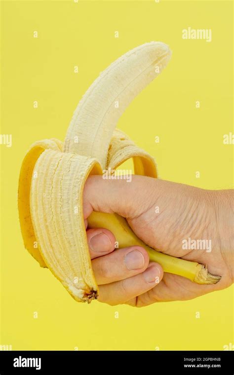 Human Hand Holding Banana On Yellow Background Nutrition Concept Stock